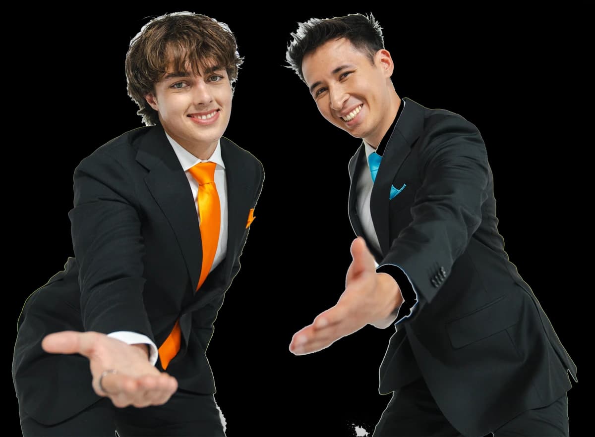 Gianni Sirgy and KingChris in black suits with orange and blue ties, arms out toward the camera.